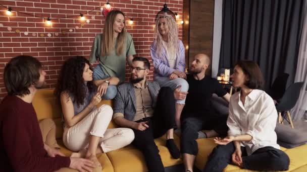 Grupp glada kaukasiska män och kvinnor i samtal på soffan, slow motion — Stockvideo