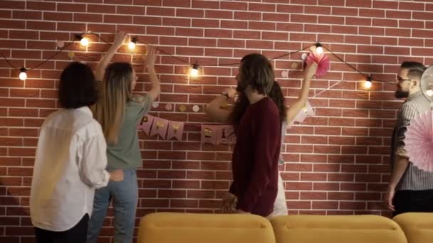 Diversas personas preparando fiesta en el interior, decorando la sala de estar — Vídeos de Stock