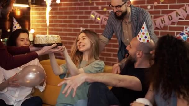 День народження дівчина насолоджується обіймами і поцілунками кращих друзів під час святкування дме торт свічка — стокове відео