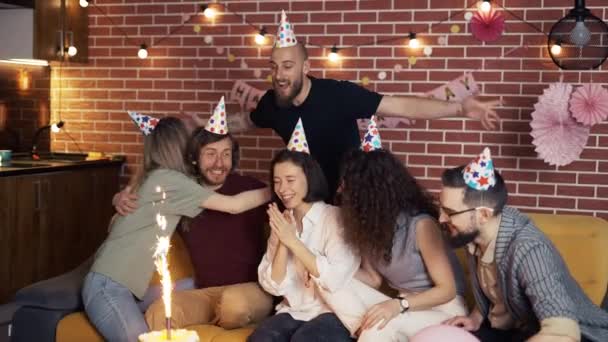 День народження дівчина насолоджується святкуванням з кращими друзями з тортом і обіймами — стокове відео
