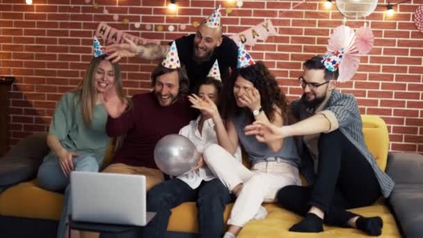 Grupa ludzi w domu świętuje urodziny nosząc kapelusze imprezowe, dysząc z zaskoczenia, mając wideo połączenie — Wideo stockowe