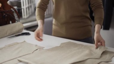 Stüdyoda kumaş desenleriyle çalışan tanınmayan moda tasarımcısı ya da terzi.