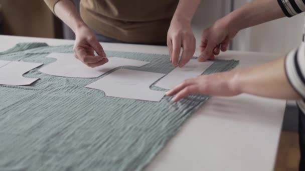 Two seamstresses working with a cloth and a chalk on a table — Vídeo de Stock
