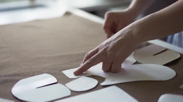Женщина портниха использует мел на рисунке контура на текстильной, в ателье — стоковое видео