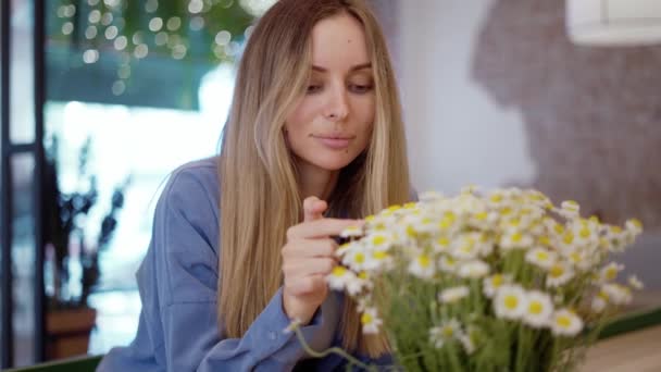 Donna bionda guardando e toccando bellissimo bouquet di fiori di camomilla — Video Stock