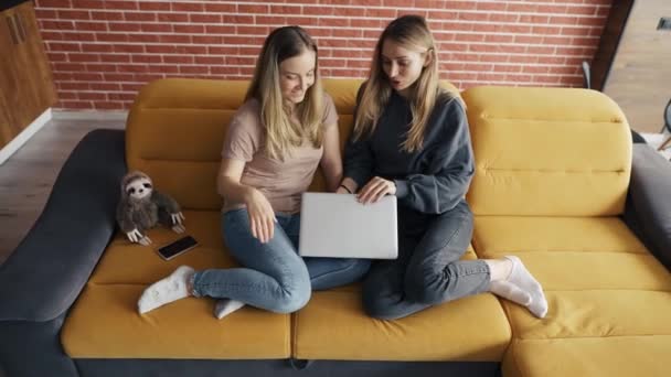 Két boldog barát ül a kanapén - záró laptop és ölelés — Stock videók