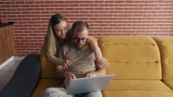 Freelancer embrasser la joue de femme gaie près d'un ordinateur portable — Video