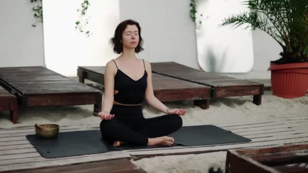Расслабляющая женщина, занимающаяся йогой и медитацией на пляже — стоковое видео