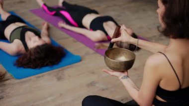 Meditasyon sırasında şarkı söyleyen bir kadın, açık havada yoga kursu.