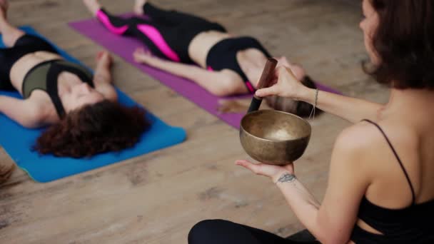 Nő használ éneklő tálak meditáció közben, ólom jóga osztály szabadban — Stock videók