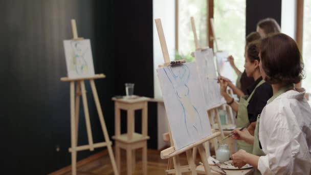 Preciosas mujeres pintando silueta femenina sobre lienzo en el taller — Vídeo de stock