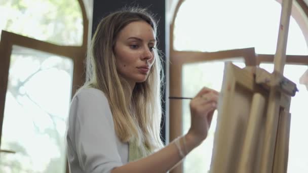 Geconcentreerde vrouw tekent een tekening in kunststudio — Stockvideo