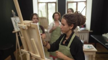 Sanat antremanındaki bayan öğrenciler akıl hocaları tarafından yönetiliyor. Talimatları dinleyin.