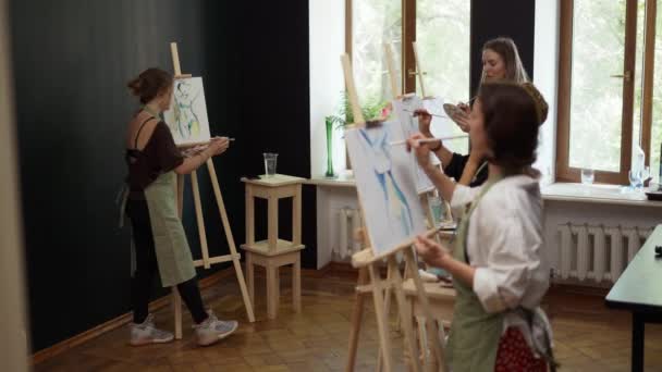 Schöne Studentinnen malen beim Kunstunterricht im Atelier — Stockvideo