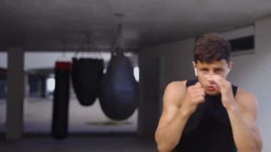 Dövüş sanatları ustası kameraya gölge boksu yapıyor.