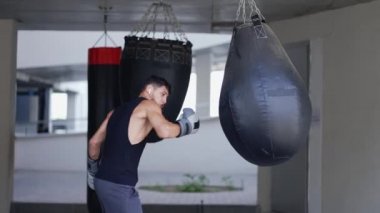 Adam boks çantasında, dışarıda sert darbeler indiriyor.