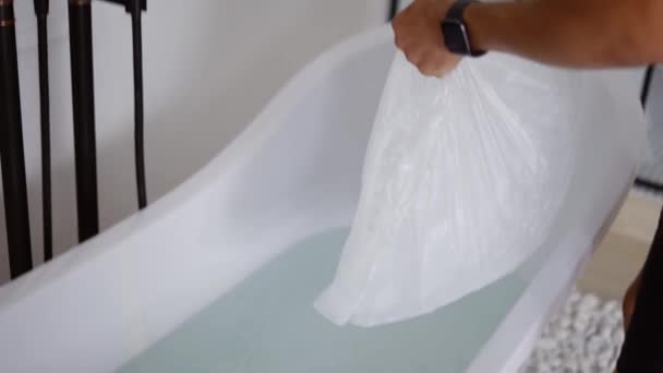 Man filling bath with ice cubes — Stock Video