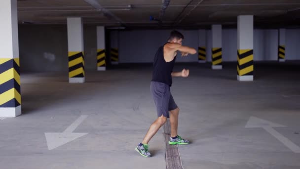 Boxer ćwiczy uderzenia na podziemnym parkingu. — Wideo stockowe