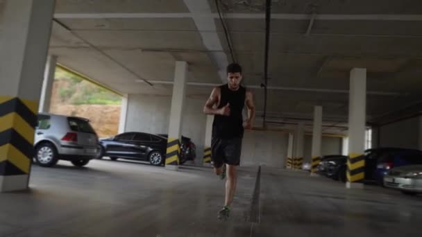 Спортсмен пробігає всередині гаража на міському паркінгу — стокове відео