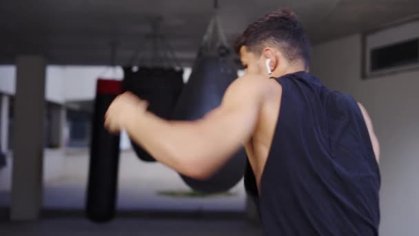 Luchador de arte marcial hace boxeo en la sombra, kickboxer golpes de entrenamiento en el gimnasio — Vídeos de Stock