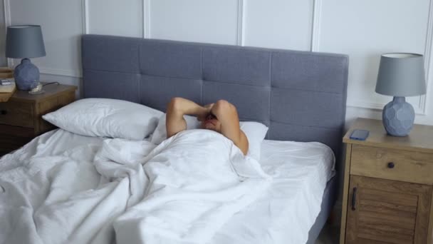 Man waking up in the morning, standing up from bed in bedroom — Stock Video