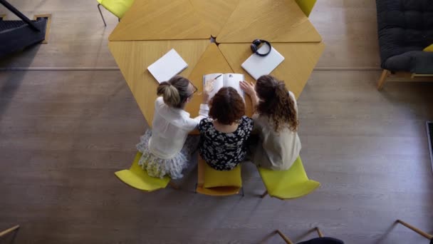 Female students discussing great ideas in library, top view — Stok Video
