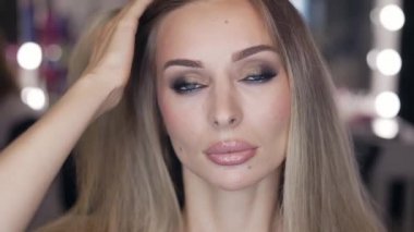 Parlak stüdyoda şık makyajlı şehvetli bir kız.