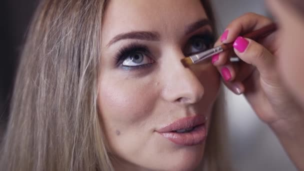 Makeup artist contouring models nose using a brush — Stock Video