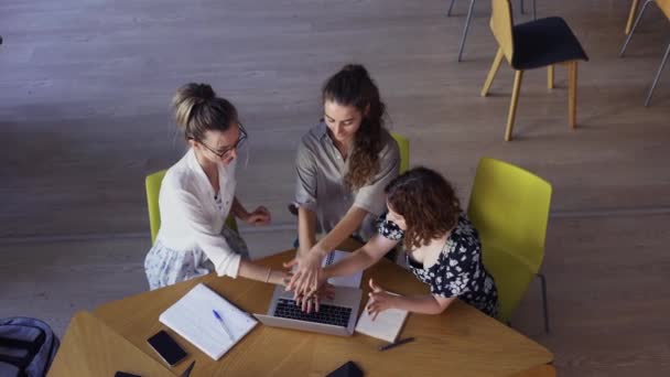 Estudiantes haciendo un trabajo en equipo en la biblioteca, juntando manos - vista de ángulo alto — Vídeos de Stock