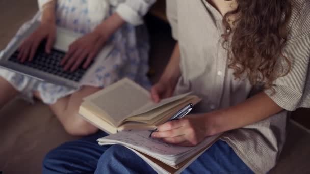 Estudantes do sexo feminino aprendendo juntas na biblioteca universitária no chão, ângulo alto — Vídeo de Stock