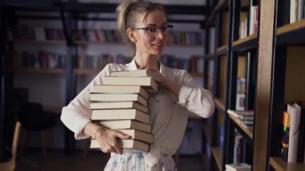 Mulher Positiva Segurando Pilha Livros Biblioteca Colocando Mais Pilha — Vídeo de Stock