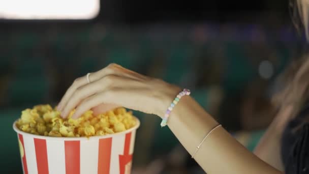 Gülümseyen sarışın sinemada patlamış mısır yiyor. — Stok video