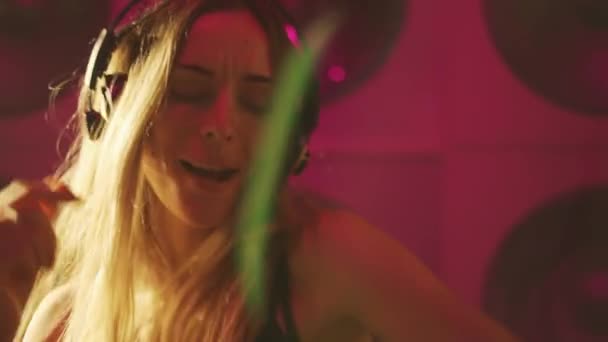 多色の照明でヘッドフォンを持つ幸せな若い女性の肖像画 — ストック動画