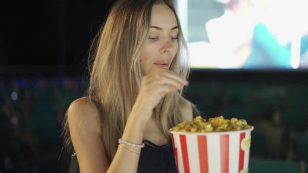 Sexig blondin äter popcorn på bio — Stockvideo