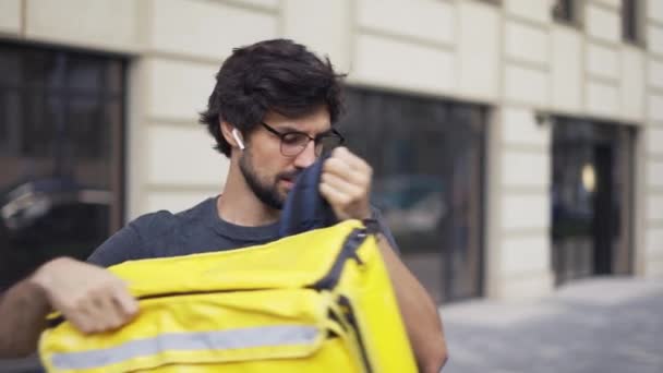 Correio com mochila olhar para dentro para obter detalhes sobre o recibo da ordem, close-up — Vídeo de Stock