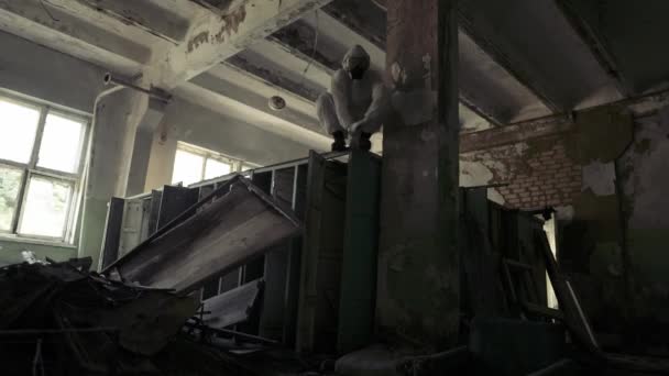 Worker in protective suit jumping from the destroyed locker to the camera — Stock Video