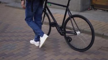 Teslimatçı, bisikletle şehrin yanından geçiyor.