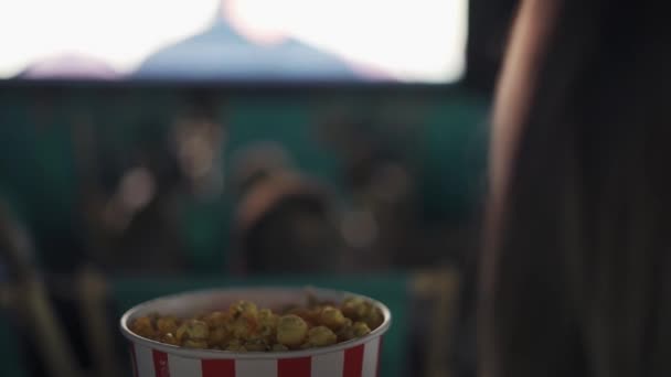 Des images par-dessus les épaules - une femme mange du pop-corn au cinéma — Video