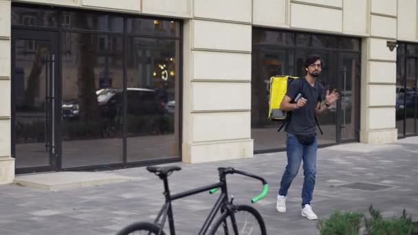 Un tipo barbudo con una mochila está tonteando y bailando, cámara lenta — Vídeos de Stock