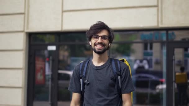 Usmívající se mladý muž doručovací služby s velkým termálním batohem — Stock video