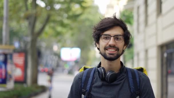 Retrato de joven guapo alegre de servicio de reparto de comida con gran mochila térmica — Vídeos de Stock