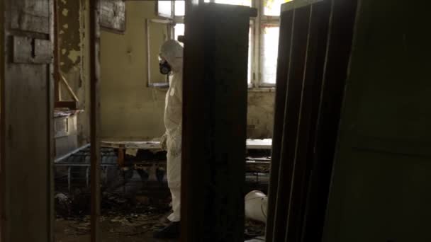 Worker in protective suit inside the ruined building — Stock Video