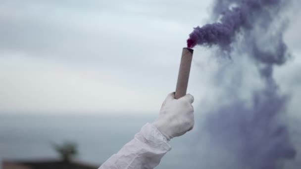 Osoba w rękawiczkach ochronnych na krawędzi dachu trzymać kij dymny — Wideo stockowe