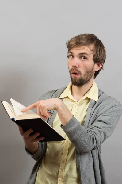 Mann zeigt mit dem Finger auf ein interessantes Buch — Stockfoto