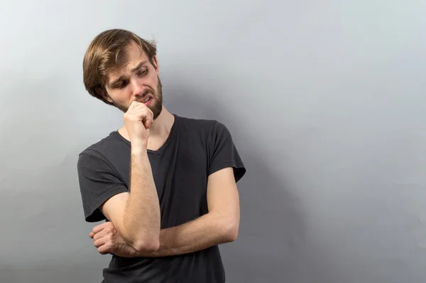 Joven evaluar aislado sobre un fondo gris — Foto de Stock