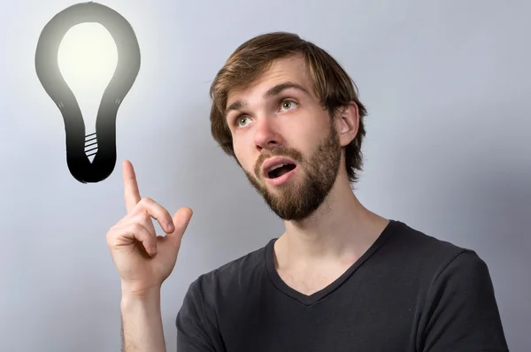 Young man with lightbulb having a good idea — Stock Photo, Image