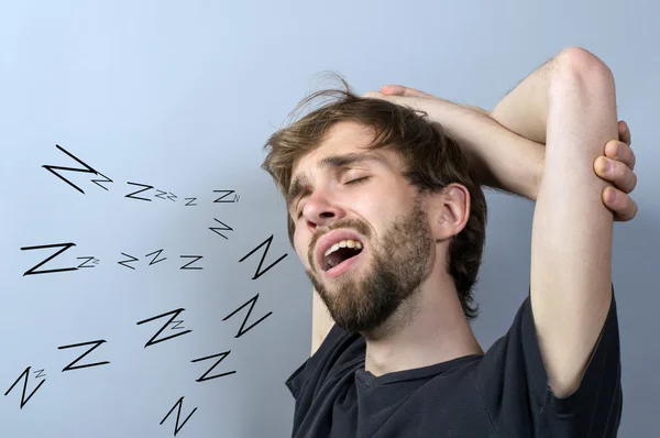 Измученный молодой человек зевает изолированные на белом фоне — стоковое фото