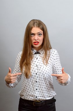 Ciddi kadın kendini gri arka plan üzerine işaret