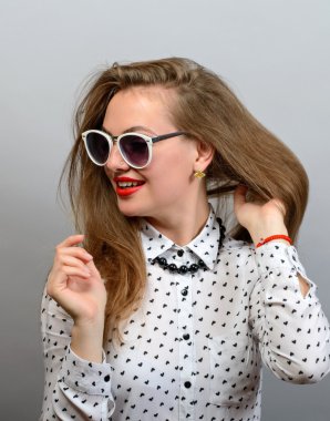 Mutlu bir genç güzel kadın gözlük kamera gri arka planı arıyorum. 