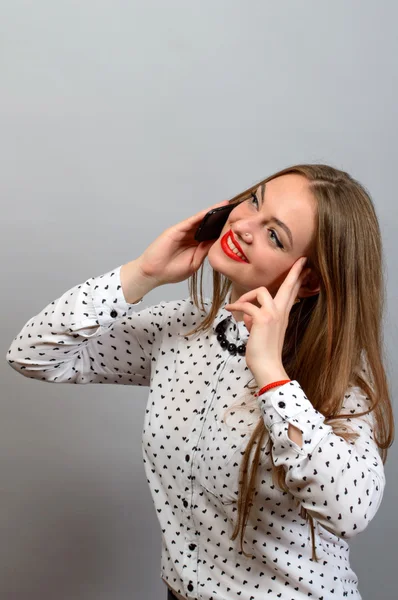 Retrato de una joven feliz hablando por teléfono sobre fondo gris. Mirando hacia arriba —  Fotos de Stock